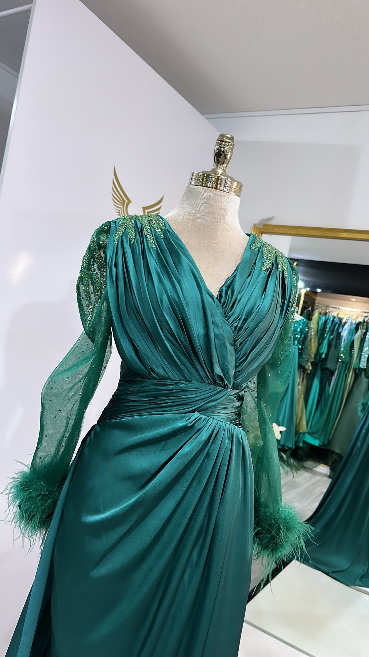 Elegant green dress decorated with beads, feathers